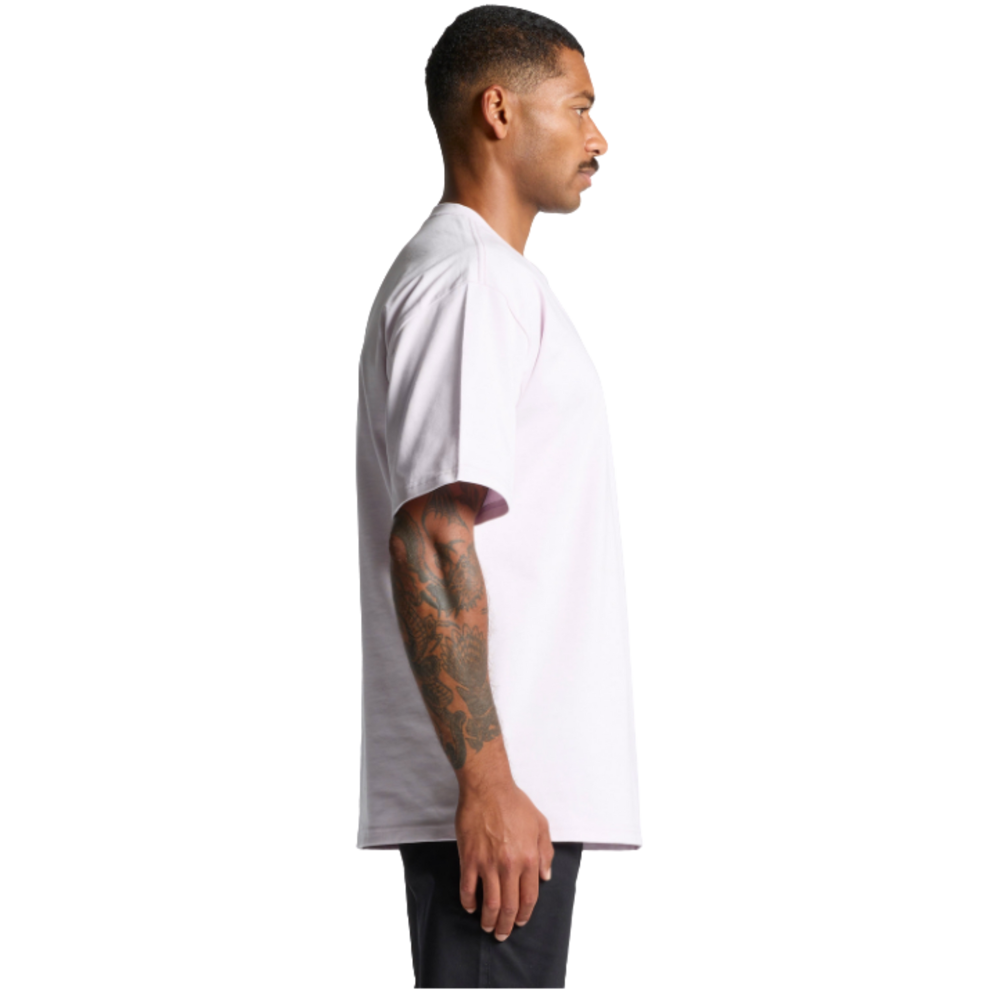 Man in white graphic tee with tattooed arm, side view, streetwear style