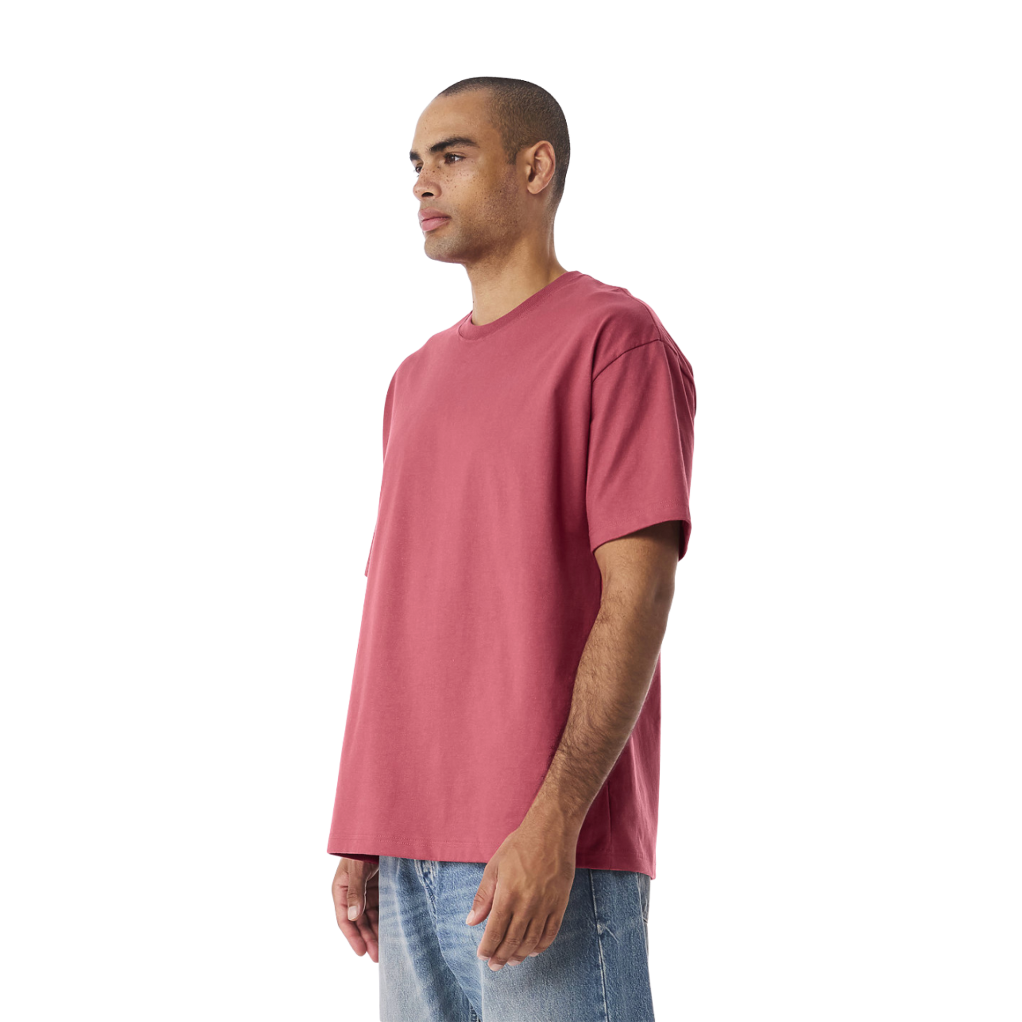 Man wearing oversized pink graphic tee with streetwear style, paired with denim jeans
