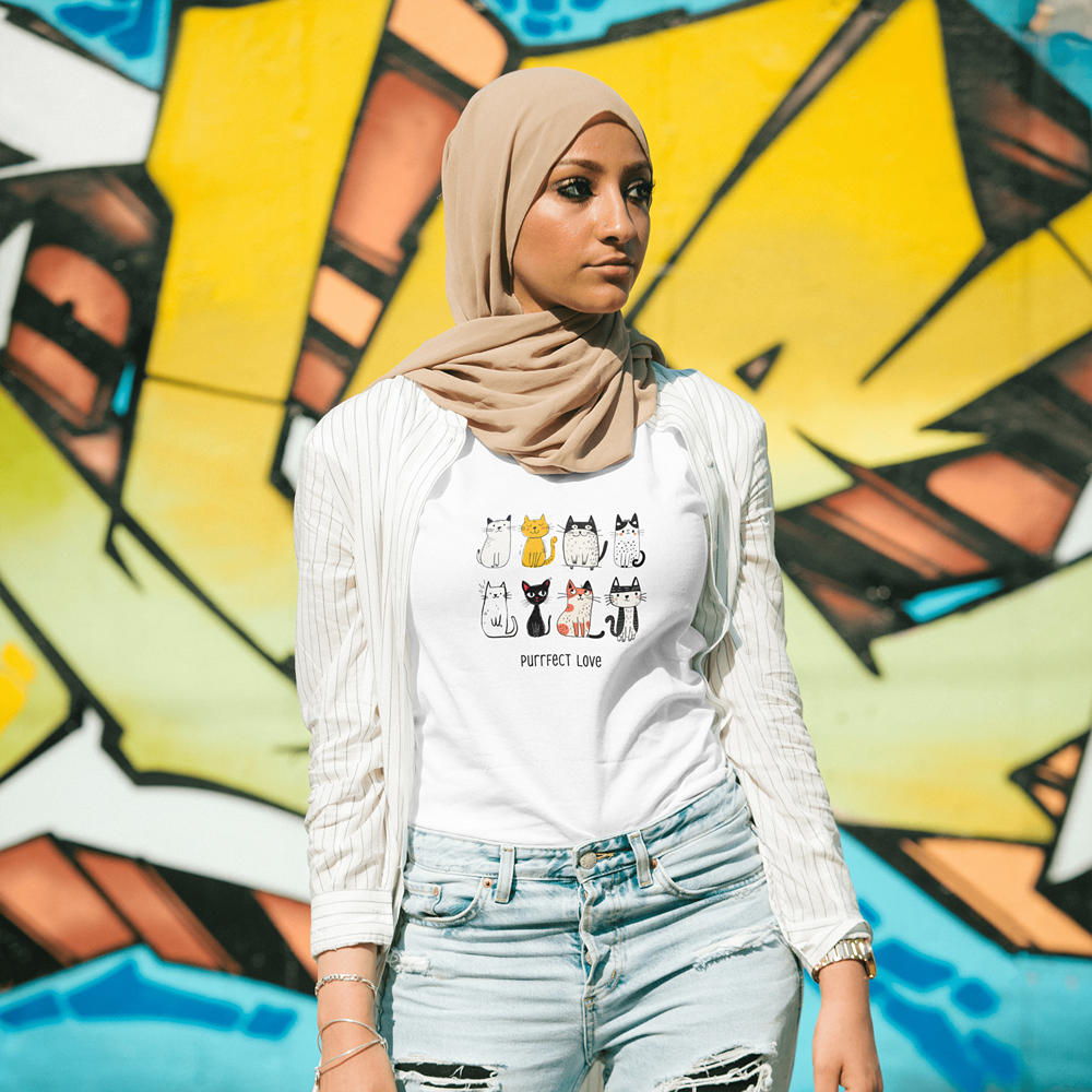 Woman wearing cat graphic tee with 'Purrfect Love' text, streetwear style against graffiti wall