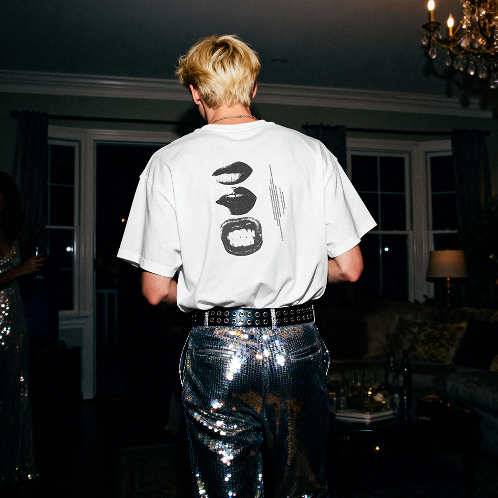 White graphic tee with bold lip print, paired with sequin pants, for edgy streetwear style