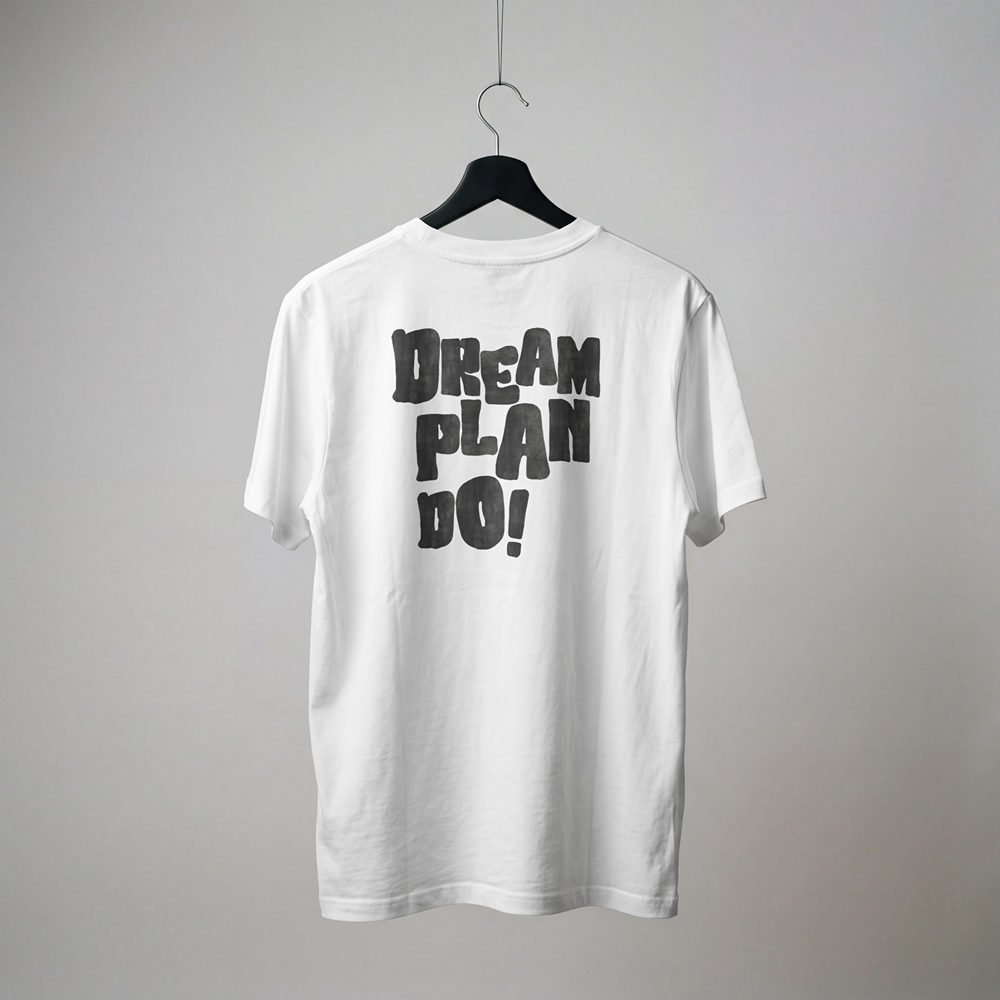White graphic t-shirt with bold 'DREAM PLAN DO!' print, streetwear style for expressive fashion